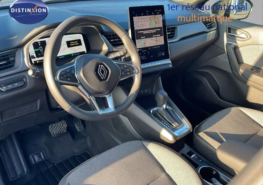 Vue intérieure côté conducteur du Renault Captur E-Tech hybride 2025, avec tableau de bord numérique et écran tactile vertical.