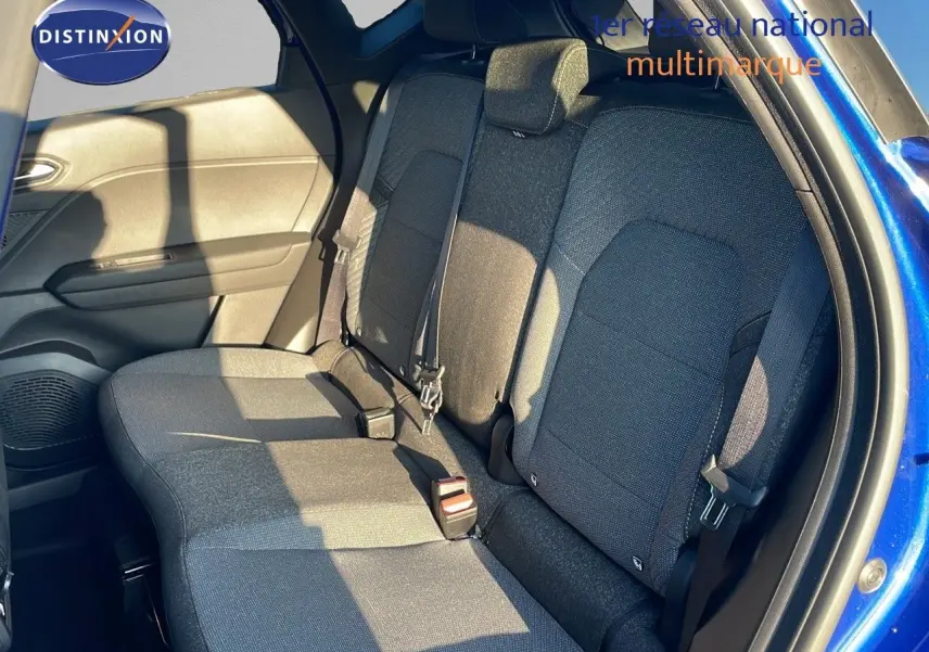 Vue du siège arrière côté droit du Renault Captur E-Tech hybride 2025 bleu Iron Metal avec intérieur tissu noir-gris.