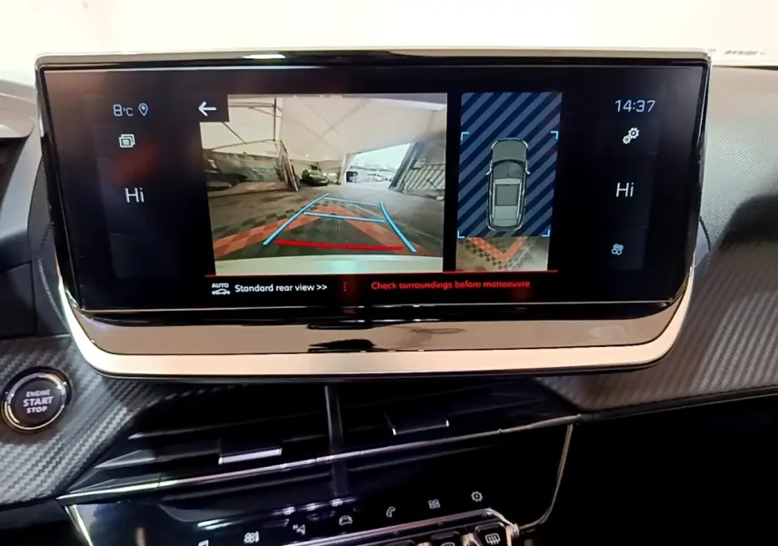 Vue intérieure du tableau de bord du Peugeot 2008 blanc, écran tactile affichant la caméra de recul et l’aide au stationnement.