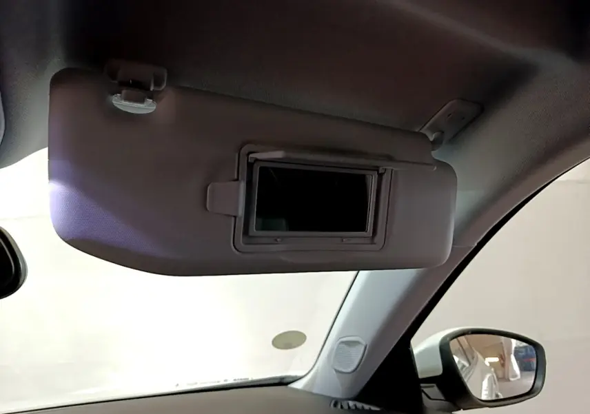 Pare-soleil côté conducteur avec miroir intégré, intérieur clair du Peugeot 2008 blanc vue depuis l'habitacle.