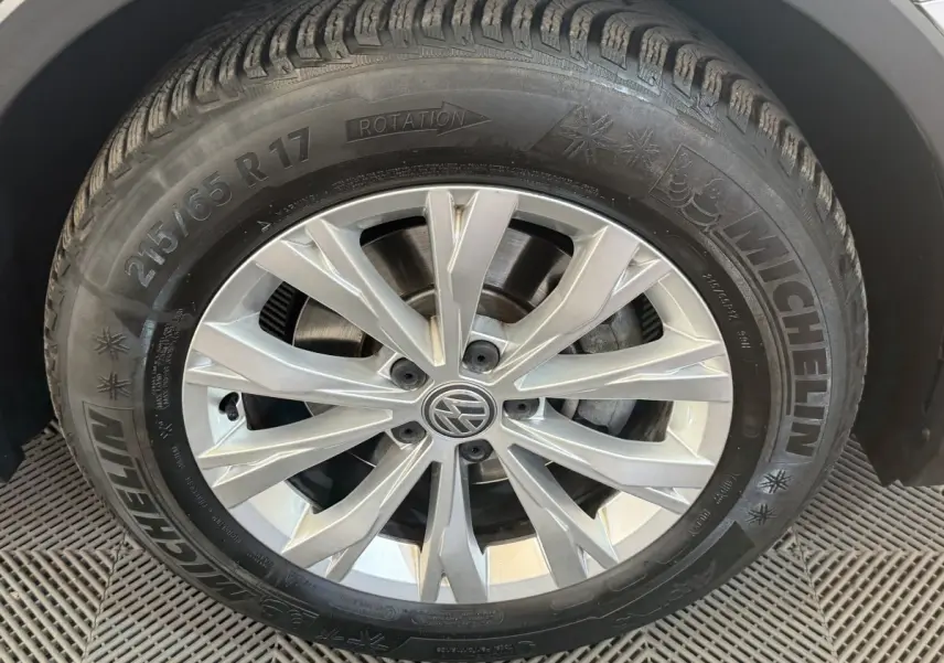 Gros plan sur la roue avant droite du Volkswagen Tiguan gris clair, avec jante alliage et pneu Michelin visible.