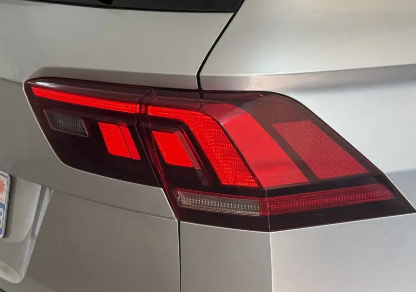 Gros plan sur le feu arrière droit rouge d’un Volkswagen Tiguan gris clair, vue arrière latérale.