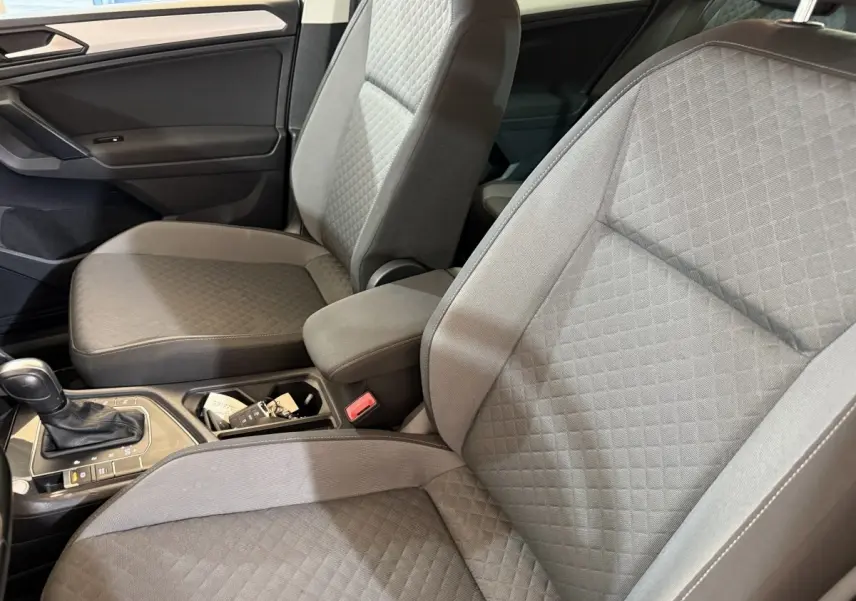 Vue intérieure rapprochée des sièges avant gris clair du Volkswagen Tiguan 2020 avec console centrale et levier de vitesses.