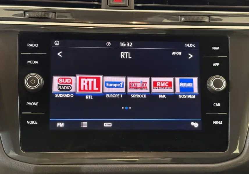Écran tactile central du Volkswagen Tiguan 2020 affichant les stations radio avec commandes autour.