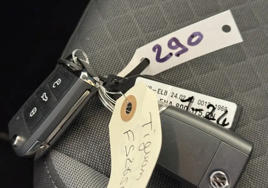 Gros plan sur la clé de contact noire du Volkswagen Tiguan 2.0 TDI gris clair posée sur un siège tissu.