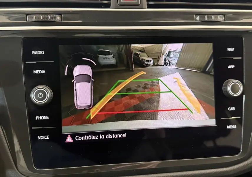 Écran tactile du système de navigation affichant la caméra de recul du Volkswagen Tiguan gris clair, vue arrière.
