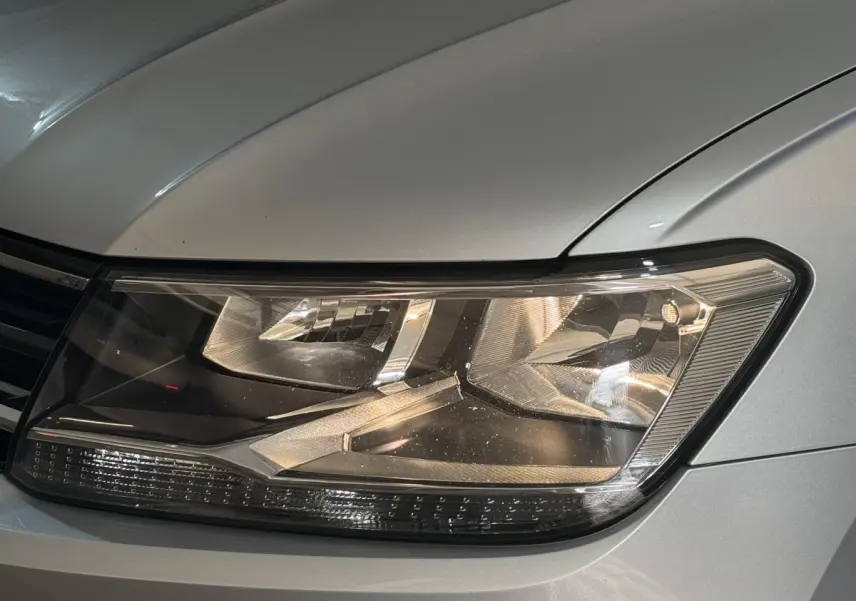 Gros plan sur le phare avant droit gris clair du Volkswagen Tiguan 2020, mettant en valeur ses détails lumineux modernes.
