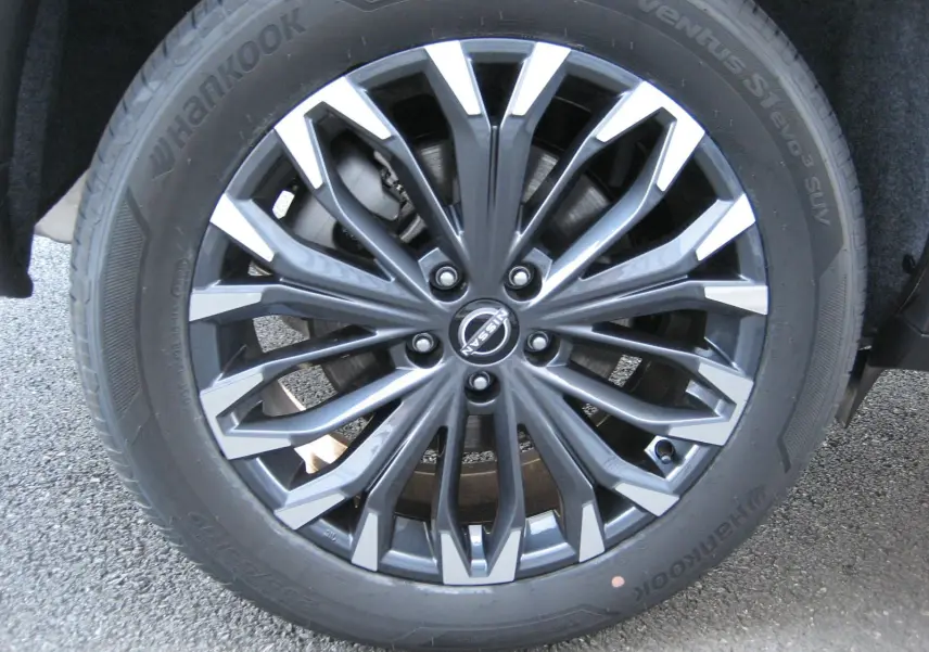 Gros plan sur la jante alliage bicolore gris et argent du Nissan X-Trail blanc nacré 2026.