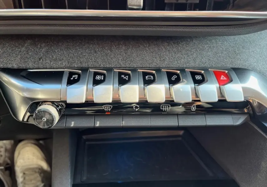 Gros plan sur la rangée de boutons argentés et noirs du tableau de bord du Peugeot 3008 2016, finition Allure Business.