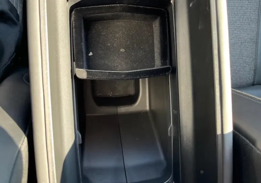 Vue rapprochée de la console centrale noire ouverte du Peugeot 3008, montrant le rangement intérieur entre les sièges.