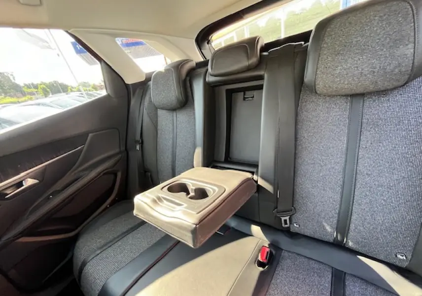 Vue intérieure arrière du Peugeot 3008 2016 montrant les sièges gris avec accoudoir central relevé et porte-gobelets intégré.