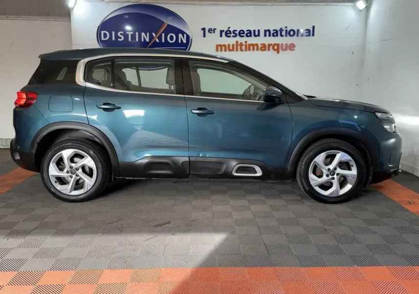 Profil latéral droit d'un Citroën C5 Aircross bleu 2021 avec toit noir et protections de bas de caisse noires.