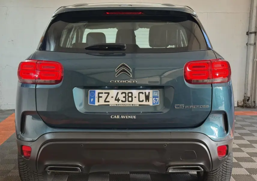 Vue arrière d'un Citroën C5 Aircross bleu avec feux arrière rouges et double sortie d'échappement intégrée.