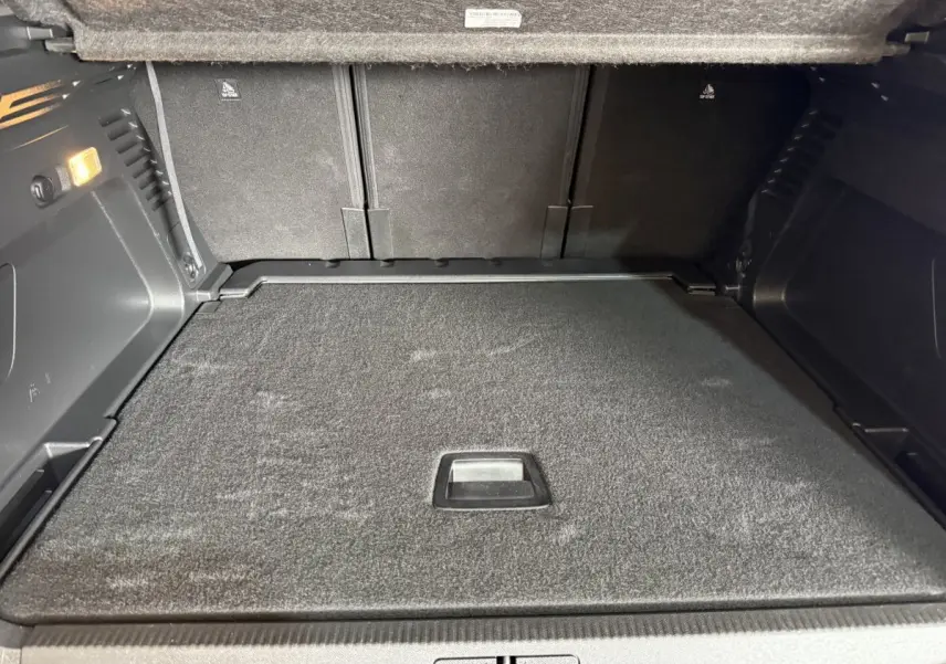 Vue intérieure du coffre spacieux et tapissé en noir du Citroën C5 Aircross 2021, avec banquette arrière rabattue.