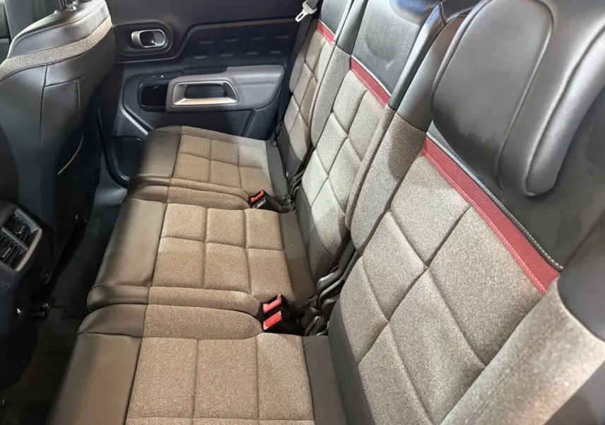 Vue latérale des sièges arrière gris et noirs avec surpiqûres rouges du Citroën C5 Aircross 2021.