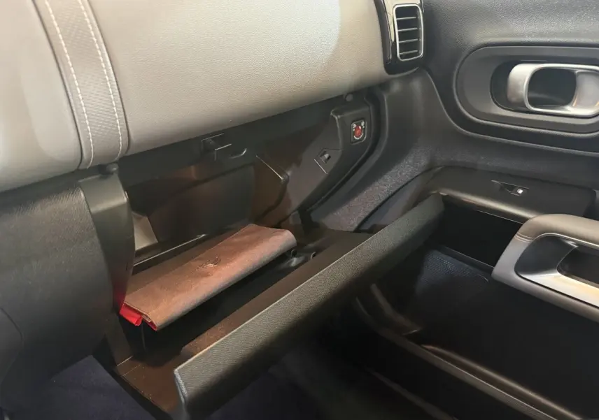 Vue intérieure côté passager du coffre à gants ouvert du Citroën C5 Aircross bleu avec détails du tableau de bord noir et gris.