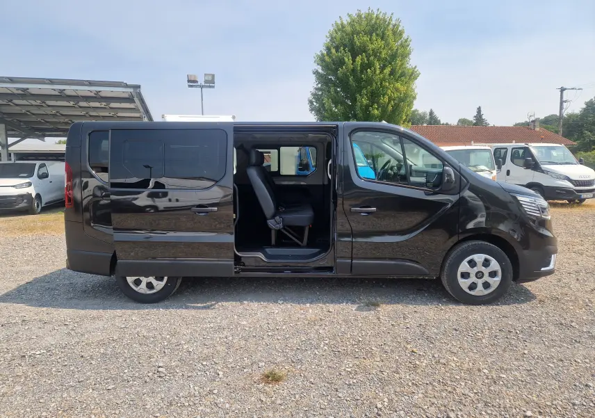 Vue latérale droite d’un Renault Trafic Combi noir 2026 avec porte coulissante ouverte montrant les sièges passagers.