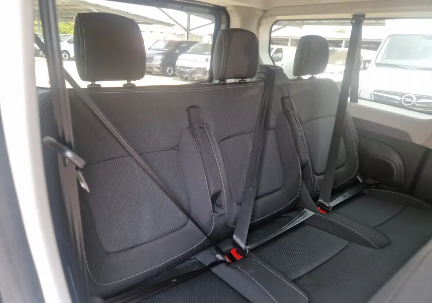 Vue intérieure du siège arrière noir du Renault Trafic Combi 2026, avec ceintures de sécurité et appuie-têtes visibles.