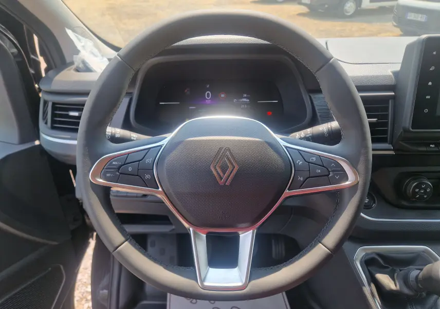 Vue centrée sur le volant noir du Renault Trafic Combi 2026, avec tableau de bord numérique et levier de vitesse manuel visible.