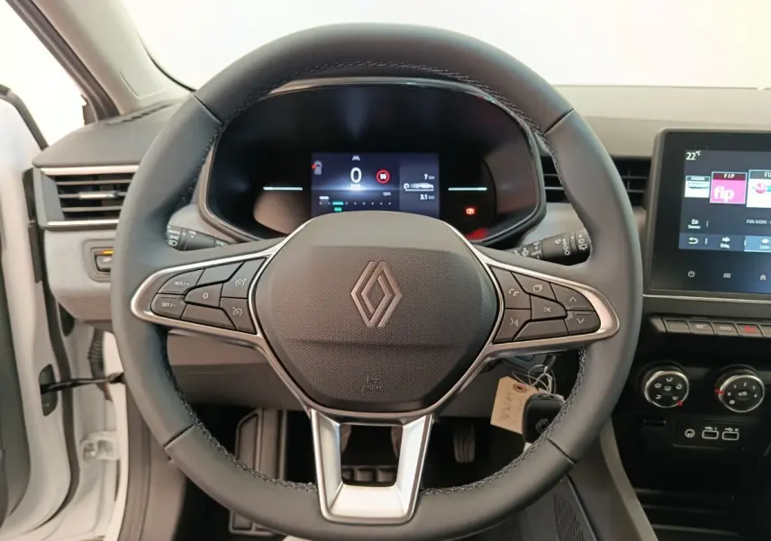 Vue frontale centrée sur le volant cuir noir de la Renault Clio blanche 2024 avec tableau de bord digital et écran tactile.
