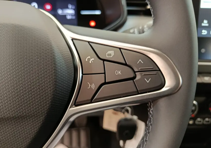 Gros plan sur les commandes multifonctions du volant cuir noir de la Renault Clio 2024, côté gauche.