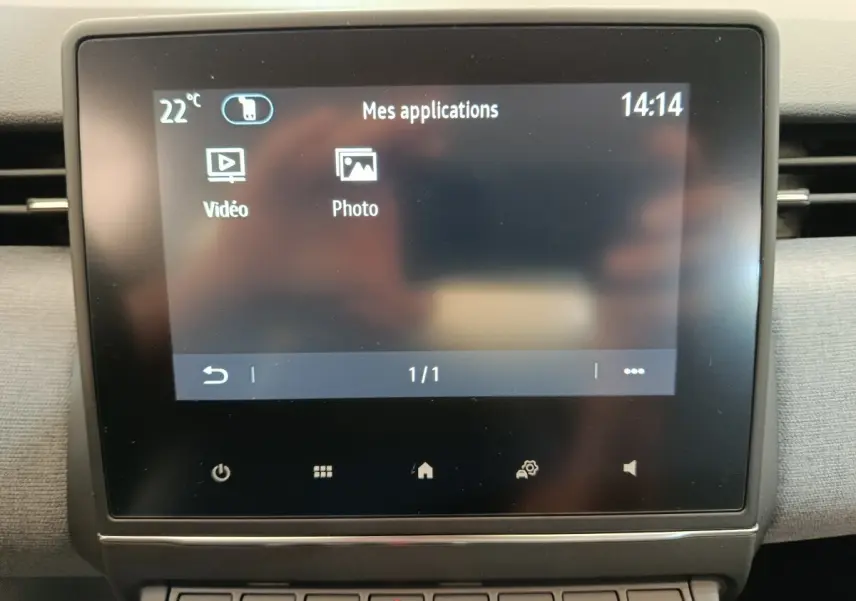 Écran tactile central affichant les applications vidéo et photo dans l’habitacle d’une Renault Clio blanche 2024.