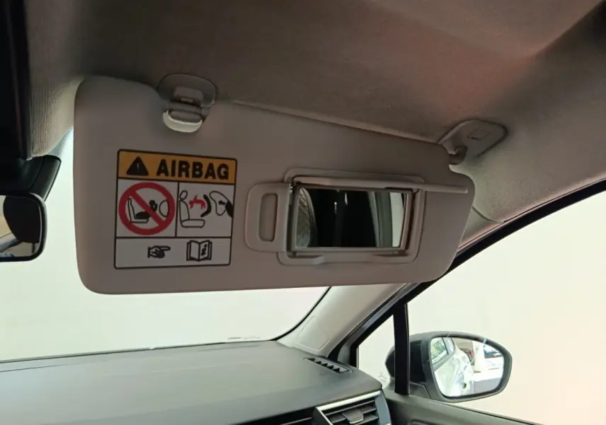 Vue intérieure côté passager du pare-soleil avec miroir et avertissement airbag dans une Renault Clio blanche 2024.