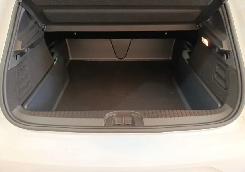 Coffre ouvert vu de l'arrière d'une Renault Clio blanche 2024, espace de chargement vide et éclairage intérieur allumé.