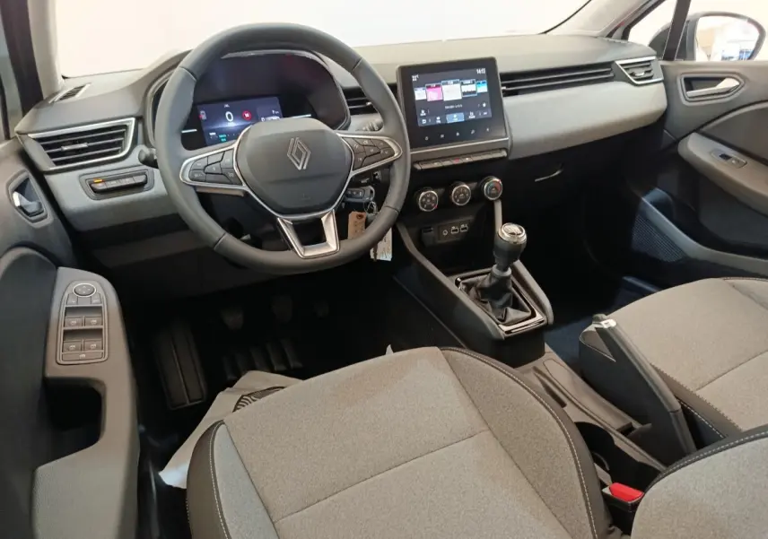 Intérieur de la Renault Clio 2024 vue côté conducteur, volant cuir multifonctions et écran tactile central visible.