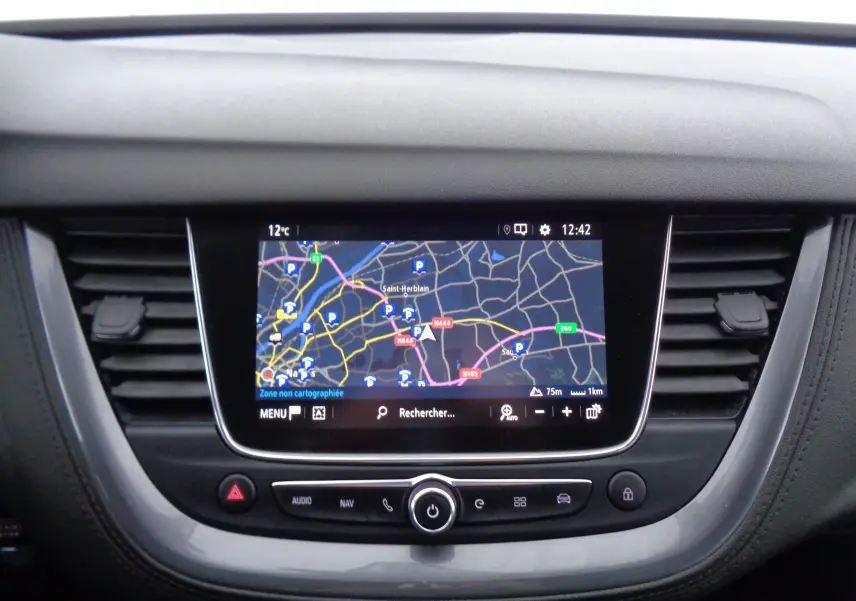 Écran tactile central avec navigation GPS affichant une carte, entouré de commandes et aérateurs noirs dans un Opel Grandland X.