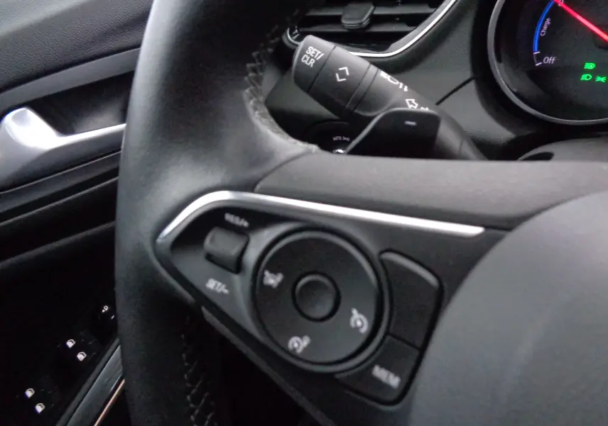 Gros plan sur le volant noir de l'Opel Grandland X 1.6 Hybrid Turbo 2021 avec commandes intégrées et tableau de bord partiel.