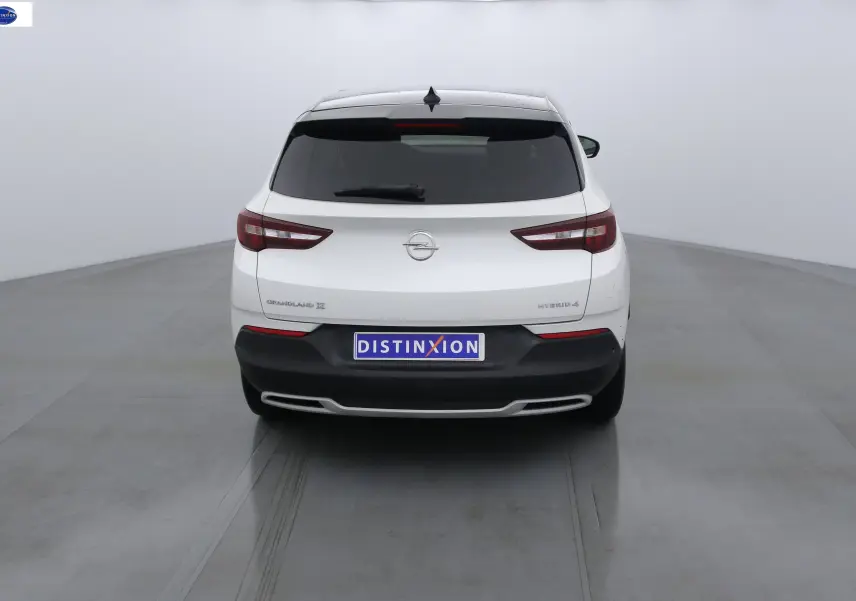 Vue arrière d'un Opel Grandland X blanc métal hybride rechargeable avec feux arrière LED et plaque Distinxion.