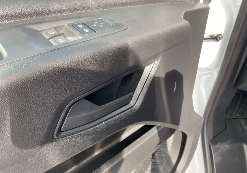 Poignée intérieure et commandes de vitres côté conducteur du Renault Master blanc, vue rapprochée de la portière ouverte.