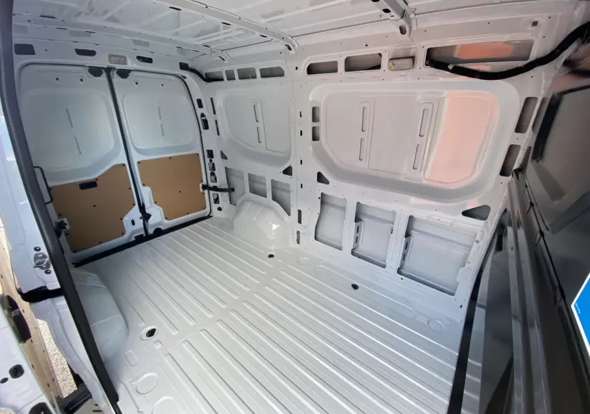 Vue intérieure arrière du Renault Master blanc 2025, montrant l'espace de chargement tôlé et le plafond avec éclairage halogène.