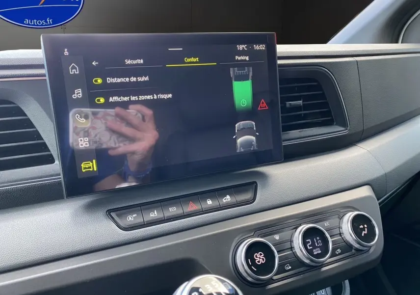 Vue rapprochée de la planche de bord du Renault Master 2025 avec écran tactile, climatisation et levier de vitesses manuel.