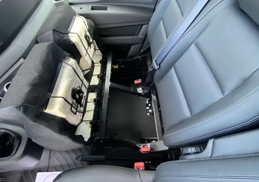 Vue rapprochée de l'intérieur du Renault Master 2025, montrant la banquette passager grise avec rangement sous l'assise.