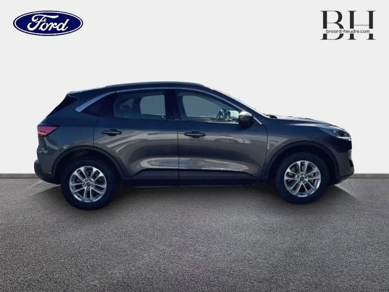 Ford Kuga gris métallisé vu de profil côté gauche, SUV compact avec jantes alliage et lignes fluides.