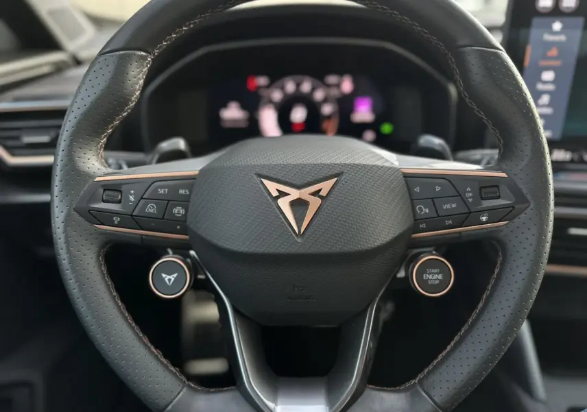 Gros plan sur le volant cuir perforé noir avec logo CUPRA cuivré et commandes intégrées du Formentor 2025.