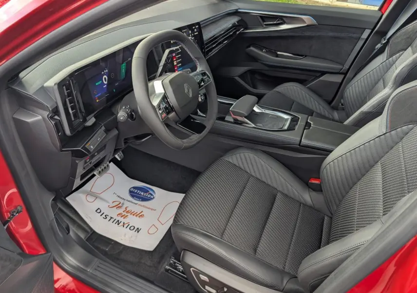 Intérieur avant droit du Renault Austral rouge métallisé, avec sièges en tissu carbone Alcantara et tableau de bord numérique.