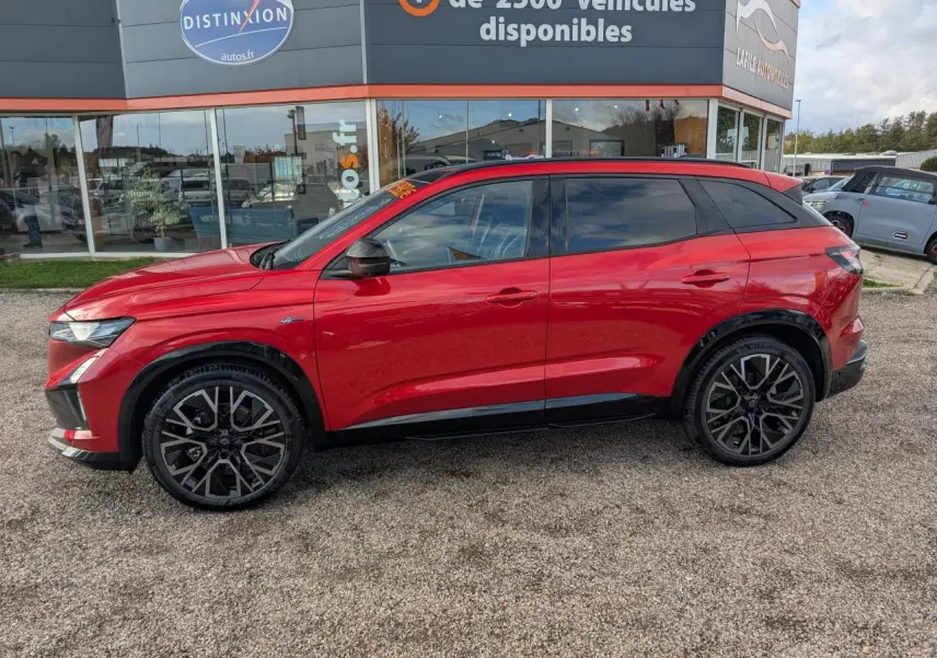 Profil côté gauche d'un Renault Austral rouge métallisé Esprit Alpine avec jantes alliage noires et toit panoramique.