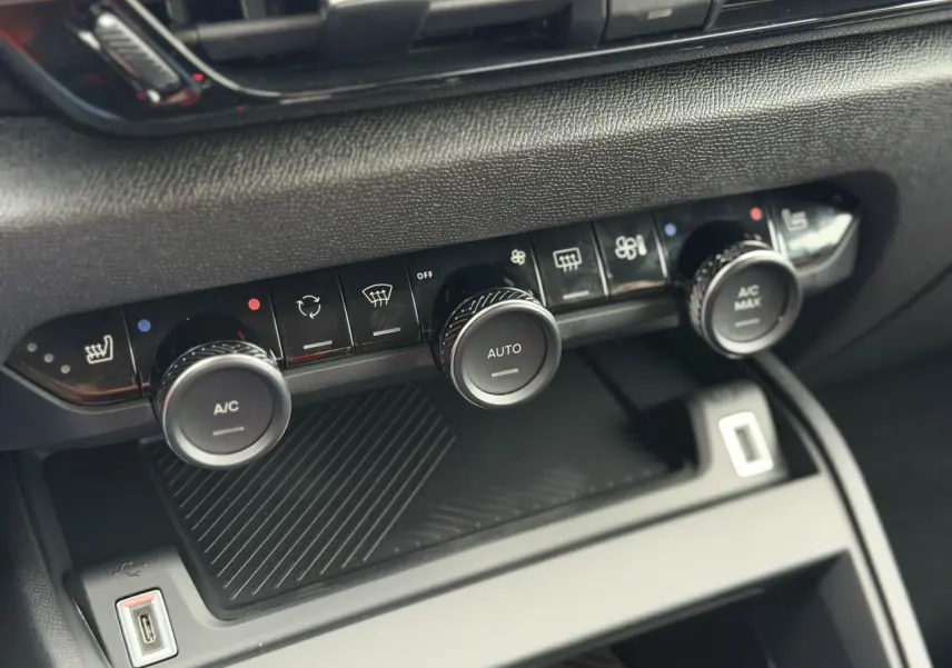 Gros plan sur la console centrale de la Citroën C4 2025, boutons de climatisation et USB visibles.