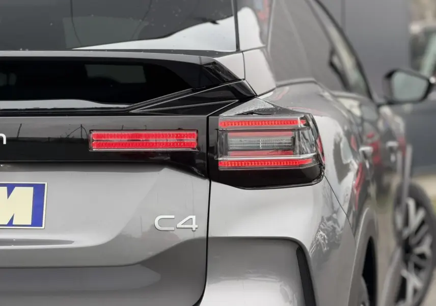 Vue arrière droite d'une Citroën C4 gris Mercury avec toit noir et feux arrière LED distinctifs.