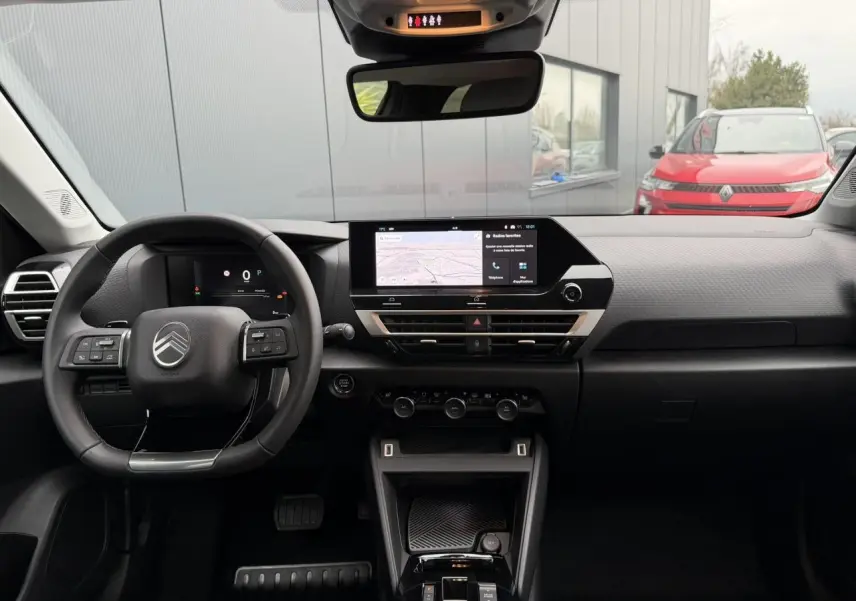 Vue intérieure avant du tableau de bord du Citroën C4 gris Mercury, avec écran tactile central et volant cuir noir.