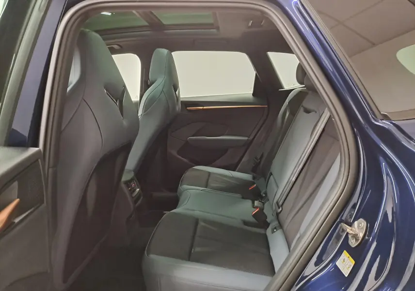 Vue intérieure côté arrière droit du CUPRA TERRAMAR 2025 bleu Cosmos, mettant en valeur les sièges et le toit ouvrant panoramique.