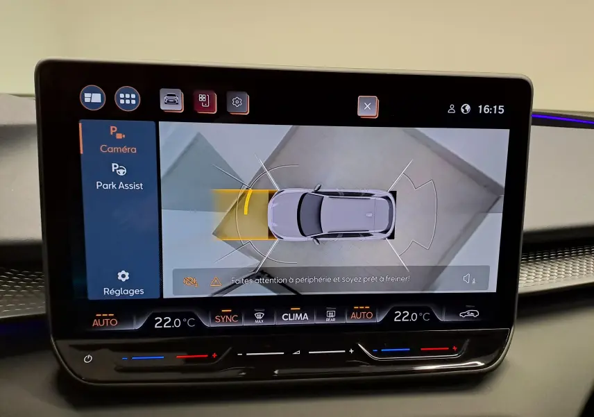 Écran tactile intérieur montrant l'aide au stationnement avec vue aérienne du CUPRA TERRAMAR bleu Cosmos et toit ouvrant panoramique.