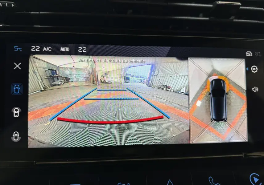 Affichage écran de la caméra de recul et vue 360° du Peugeot 308 rouge en stationnement intérieur.
