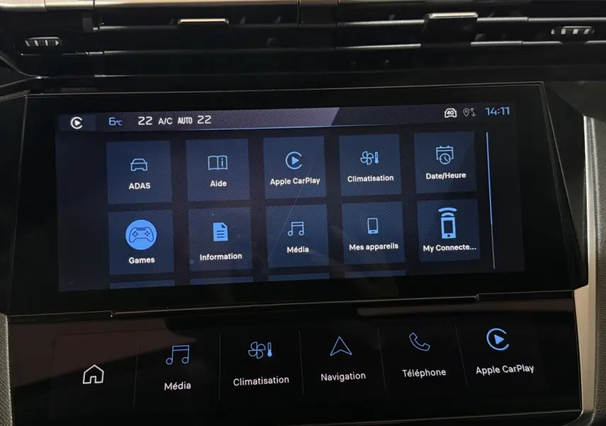 Écran tactile central de la Peugeot 308 rouge, affichant les options multimédia et climatisation en intérieur.