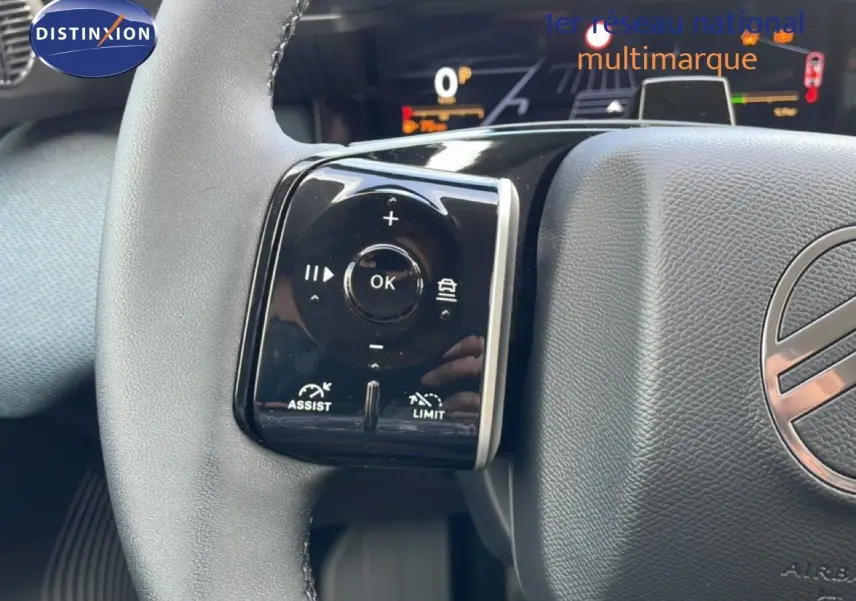Gros plan sur les commandes au volant du Citroën C5 Aircross Hybrid, volant en cuir noir avec logo central visible.