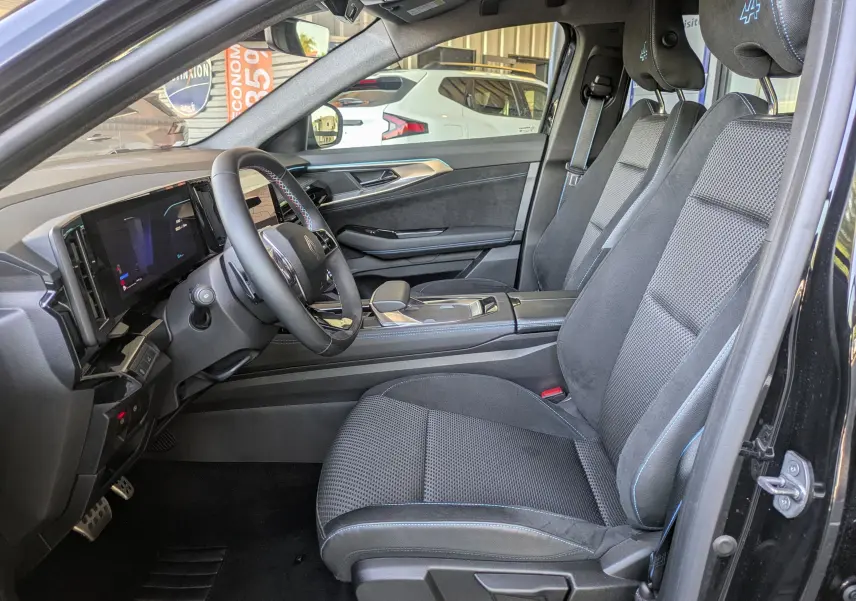 Vue intérieure côté conducteur du Renault Espace VI noir Étoile, sièges tissu/Alcantara avec surpiqûres bleues et logo Alpine sur appui-tête.