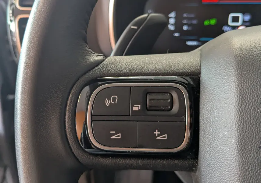 Gros plan sur les commandes vocales et volume au volant noir du Citroën C5 Aircross 2024, finition Alcantara.